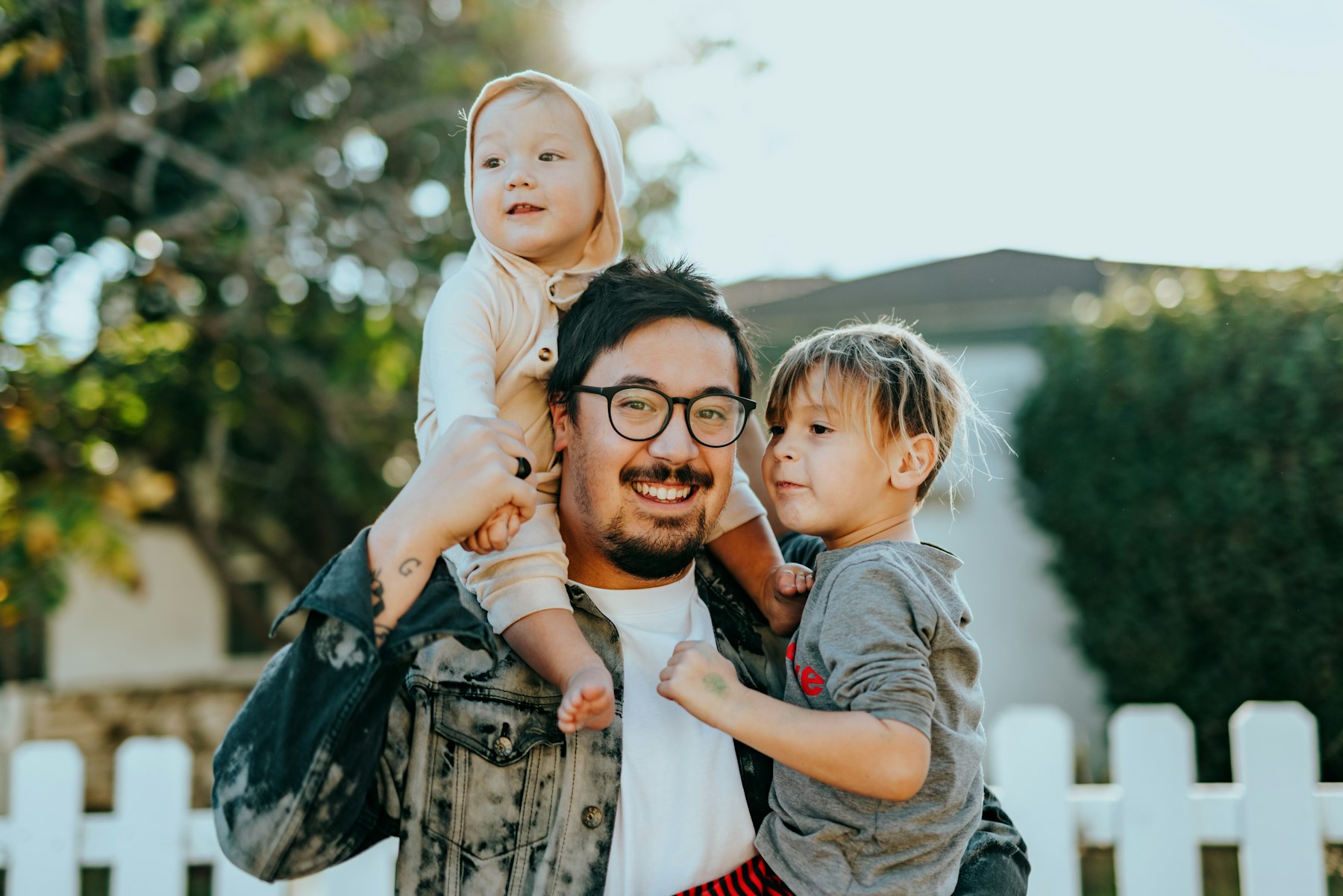 A father outdoors with his two children